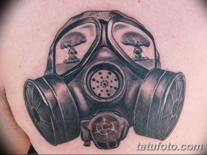 Фото тату черного противогаза с изображением ядерных взрывов в линзах. Рисунок татуировки выполнен в черно-белой гамме.