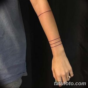 Черно-белое фото татуировки на запястье, состоящей из трех тонких горизонтальных линий, выполненных в минималистичном стиле.