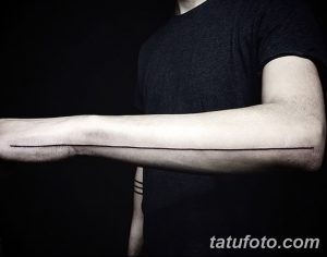 Черно-белое фото татуировки на предплечье, представляющей собой одну длинную горизонтальную линию, выполненную в минималистичном стиле.