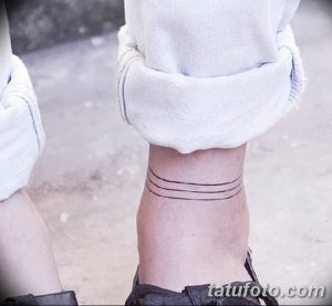 Черно-белое фото татуировки на лодыжке, состоящей из трех тонких горизонтальных линий, выполненных в минималистичном стиле.