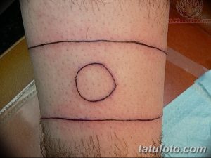 Фото тату: минималистичная татуировка на голени, состоящая из двух горизонтальных полос и круга между ними. Простой и стильный дизайн.
