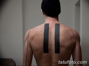 Фото тату: две вертикальные черные полосы на спине. Минималистичный рисунок татуировки, выполненный в технике тонких линий.