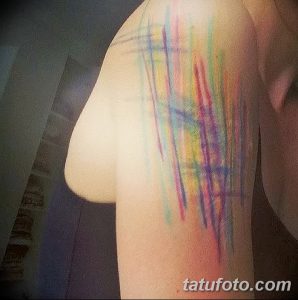 Акварельная татуировка на плече, выполненная в ярких цветах, с использованием техники размытия и переходов.