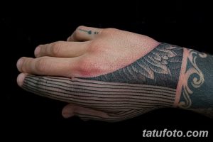 Черно-серая татуировка на руке, покрывающая ладонь и запястье, с геометрическим узором и использованием техники затенения.