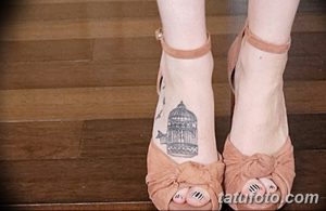 Небольшая черно-серая татуировка на лодыжке с изображением клетки и летящей птицы. Минималистичный и изящный дизайн.