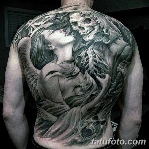 Фотография масштабной черно-серой татуировки на спине, изображающей ангела, обнимающего скелета, выполненной в реалистичном стиле.