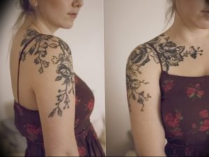 Фото тату: Большая татуировка с цветочным орнаментом, покрывающая плечо и шею девушки. Изящный и детализированный рисунок.