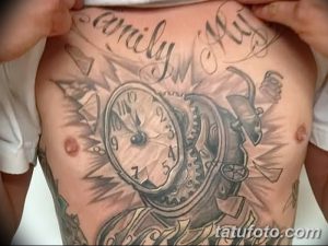Фото тату на груди с изображением старинных часов, окруженных летящими бумагами и надписью 'family first'.