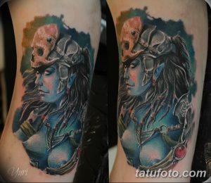 Colorful tattoo of a fierce Viking warrior woman with a skull helmet, intricate braids, and detailed armor, showcasing a bold and powerful design.