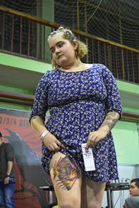 Фото тату на бедре женщины. Изображена яркая и детализированная гусеница, выполненная в стиле реализм. Необычный и привлекательный рисунок.