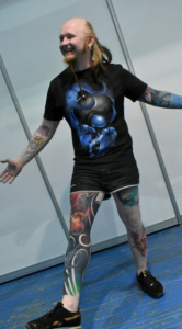 Фото тату: Мужчина с яркими татуировками на руках, ногах и торсе. Разнообразные рисунки в стиле аниме и фэнтези.