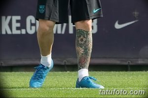 Крупный план татуировки на голени Лионеля Месси, изображающей футбольный мяч в окружении цветов и других символов.