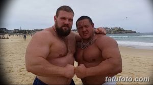 Фотография двух мужчин на пляже, один из которых с татуировкой на груди. Яркое изображение передает атмосферу летнего отдыха и дружеского общения.