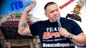 Фото тату на предплечье: красочный рисунок с элементами абстракции и надписями, выполненный в ярких цветах на фоне городского пейзажа.