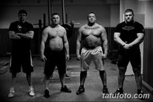 Фотография группы мужчин в спортзале, демонстрирующая татуировки на их телах. Подходит для поиска идей для тату в спортивном стиле.