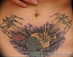 Фото тату на животе: сцена из Звездных войн с участием истребителей X-wing и Звезды Смерти, выполненная в ярких цветах. Фантастический рисунок татуировки для поклонников саги.