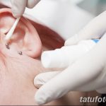 Фото процесса ухода за свежим пирсингом уха с использованием антисептика и ватной палочки. Важный этап заживления.
