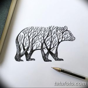 Черно-белое фото тату медведя, тело которого состоит из деревьев и ветвей. Детализированный рисунок, выполненный в графическом стиле.