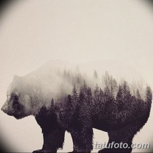 Черно-белая татуировка с изображением медведя, тело которого постепенно переходит в силуэт леса. Оригинальный и креативный дизайн.