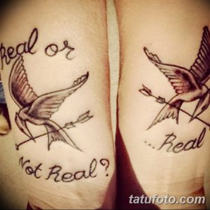 Фото тату: два парных тату соколов, пронзенных стрелами, с надписями 'Real or Not Real?' на предплечьях.