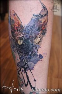 Фото акварельной татуировки кошки на руке. Пастельные тона, размытые линии, эффект акварельной живописи, детализированные глаза.