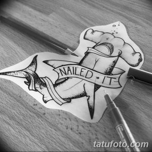 Фото эскиза татуировки акулы-молота с надписью "Nailed It!". Черно-белый рисунок, юмористический стиль, оригинальный дизайн.