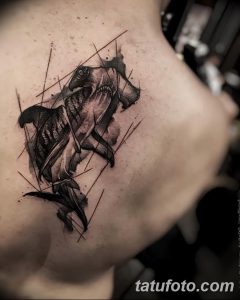 Фото акварельной татуировки акулы-молота на плече. Использование черных и серых оттенков с эффектом размытия. Оригинальный рисунок татуировки.