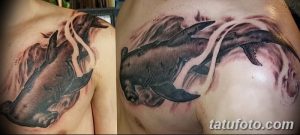 Фотография реалистичной татуировки молотоголовой акулы на груди мужчины. Татуировка выполнена в черно-серых тонах с использованием теней и световых эффектов.