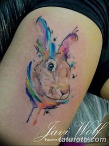 Фото акварельной татуировки зайца на плече. Яркий и красочный рисунок с размытыми краями.