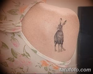 Фото минималистичной татуировки зайца на плече. Черно-белый рисунок с простыми линиями и небольшим размером.