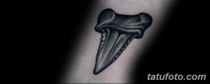 Фото тату на руке: простой рисунок зуба, выполненный в технике blackwork. Минималистичный стиль и небольшие размеры.