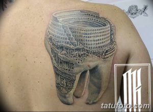 Фото тату на плече: зуб, внутри которого изображен Колизей, выполненный в реалистичном стиле с высокой детализацией.