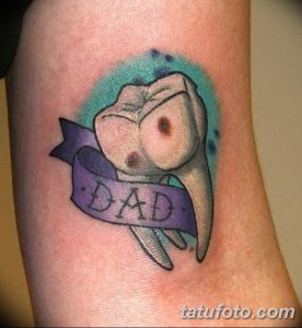 Фото тату на руке: зуб, перевязанный лентой с надписью "DAD", выполненный в нежных пастельных тонах.