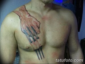 Фото татуировки медвежьей руки с когтями на груди, выполненной в реалистичном стиле с использованием красных и черных оттенков. Агрессивный и мощный рисунок.