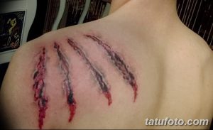 Фото тату с изображением глубоких царапин на спине, словно оставленных когтями. Реалистичный рисунок татуировки с использованием красных и черных оттенков.