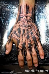 Фотография 3D татуировки скелета руки, создающей иллюзию отсутствия кожи. Детализированный рисунок костей и сосудов.
