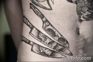 Фото тату с изображением ножей и черепов, выполненное в реалистичном стиле. Детализированный рисунок, создающий эффект трехмерности.
