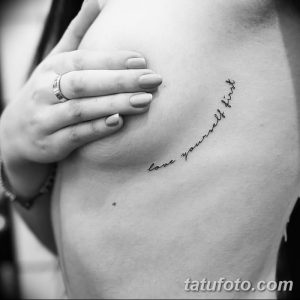 Нежная татуировка на боку с надписью "love yourself first", выполненная тонким шрифтом. Символ самолюбия и принятия себя.