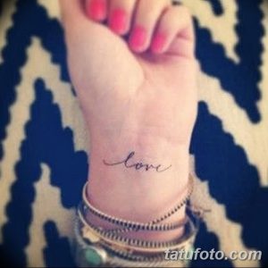Фото тату на запястье с надписью "love", выполненной изящным шрифтом, символизирующей любовь и привязанность.