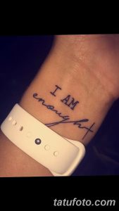 Фото тату: надпись 'I AM enough' на запястье. Черно-белая татуировка, мотивирующий рисунок для девушек.