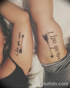Фото тату: парные татуировки с надписью 'I love you more' и стрелами с перьями на предплечьях. Черно-белые татуировки, популярный выбор для пар.