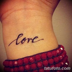 Небольшая черная татуировка на запястье с надписью 'Love', выполненной элегантным рукописным шрифтом. Простой и стильный способ выразить свои чувства.