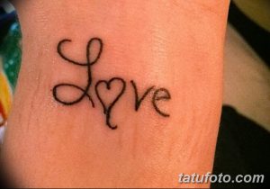 Фото тату: надпись 'Love', где буква 'o' заменена на сердечко, на запястье. Милая и романтичная татуировка, выражающая любовь и нежность.