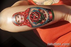 Фото татуировки матрешки с розами на локте. Яркий и красочный рисунок татуировки для девушек.