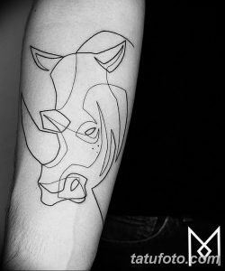 Фото минималистичной татуировки носорога, выполненной в стиле line art на руке. Рисунок состоит из тонких линий, образующих силуэт животного.