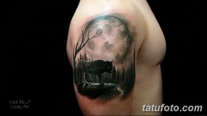 Фото тату волка, воющего на луну. Черно-белый рисунок, реалистичное изображение леса, лунный свет, драматичная атмосфера.