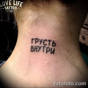Фото татуировки на затылке с надписью 'Грусть внутри', выполненной черным цветом. Простой шрифт, минималистичный стиль.