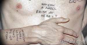 Фото татуировки с надписью "How can a angel break my heart?" на груди. Черно-белый рисунок, выполненный от руки. Выразительный эскиз тату для тех, кто пережил разбитое сердце.
