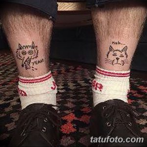 Фото тату двух кошек на голенях, одна с надписью 'YEAH', другая с надписью 'nah...'. Оригинальный и юмористический рисунок татуировки.