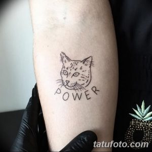 Фото тату на предплечье: контурный рисунок кошки с надписью 'POWER' под ней. Минималистичный стиль, черные линии.